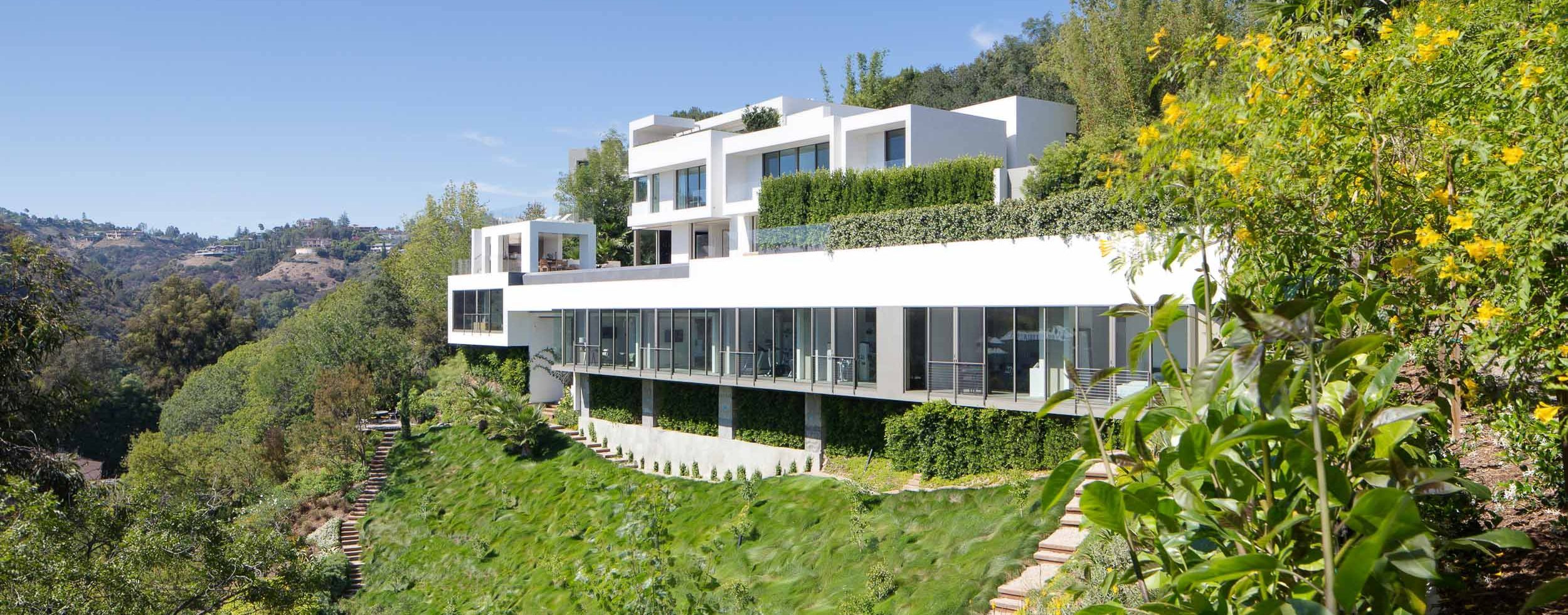 large white modern home on steep slope