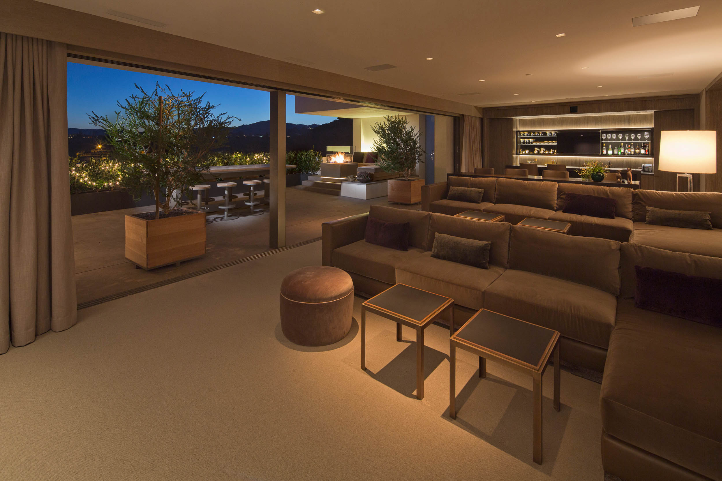 living room and kitchen open to patio with trees