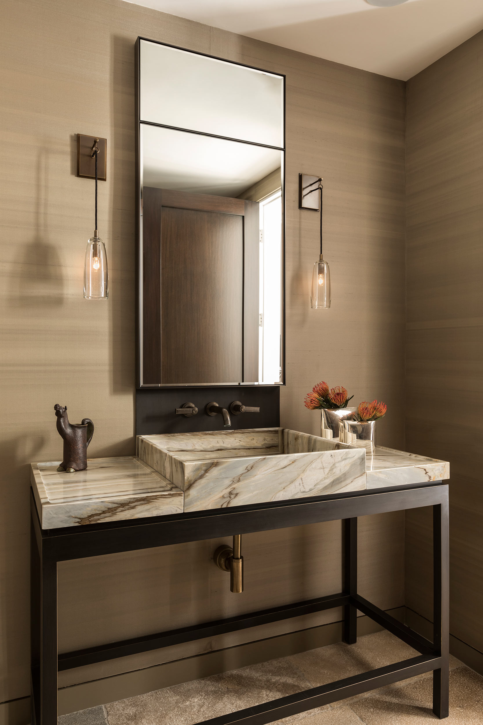 A custom metal and stone vanity makes a statement in the powder room