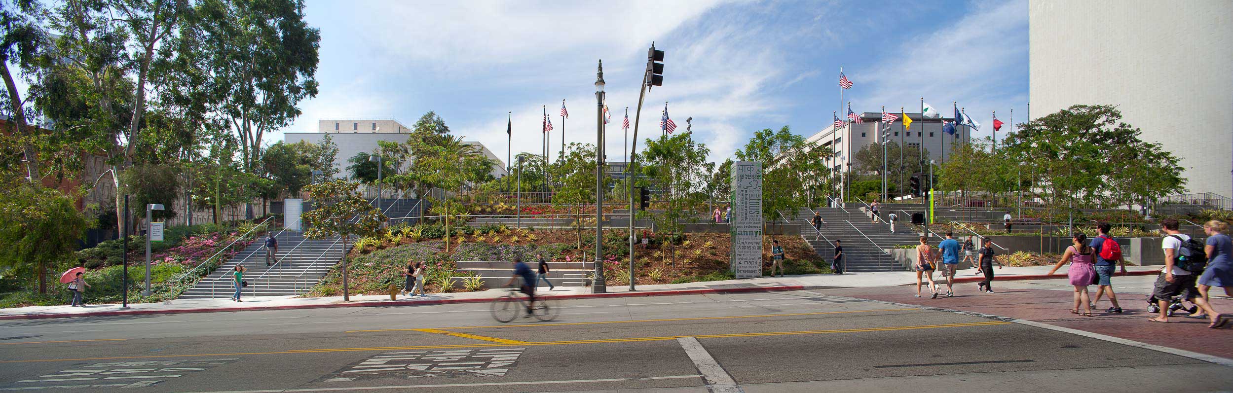 Street view of grand park stairs with people riding their bikes and pedestrians walking up