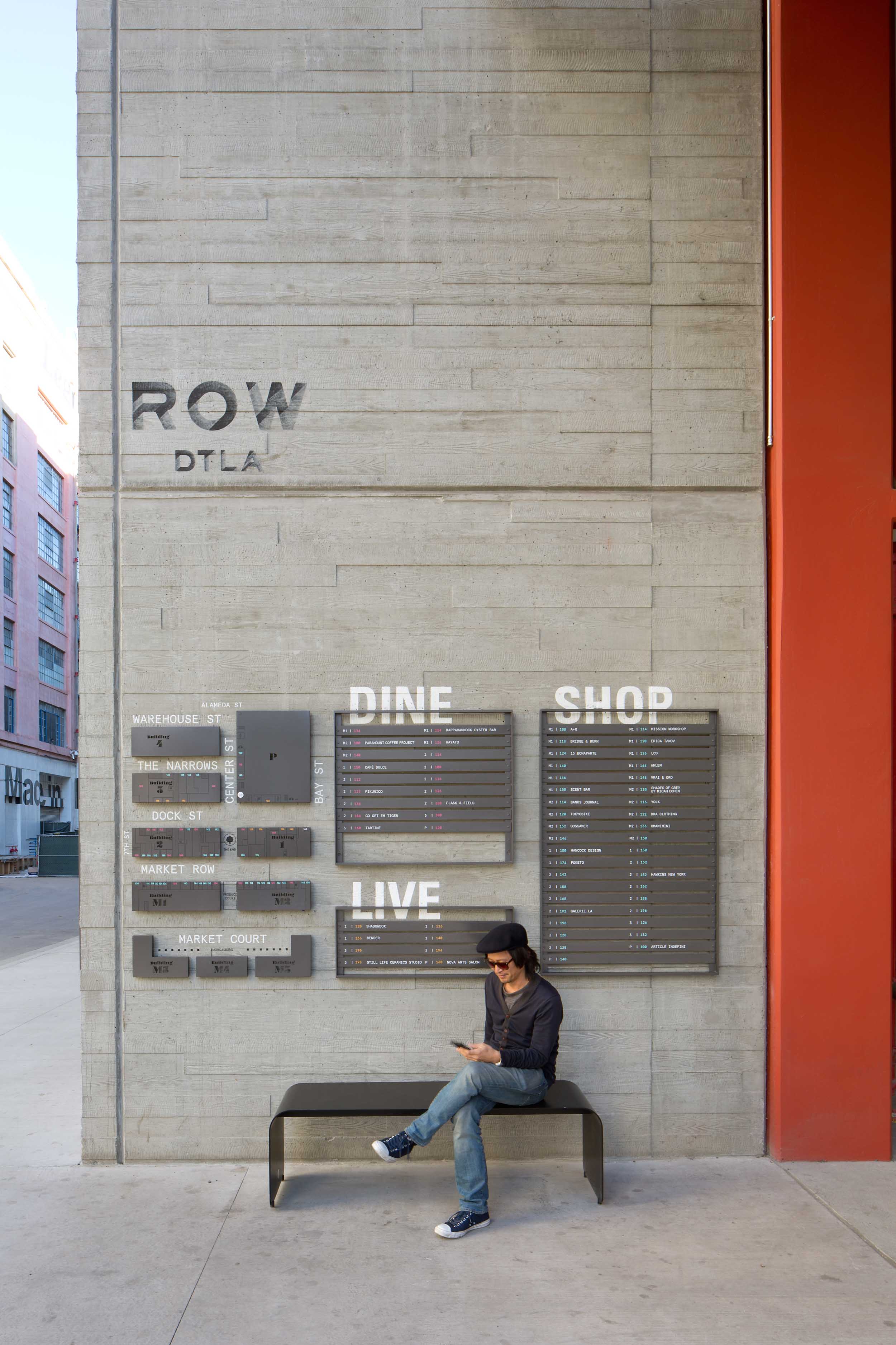 woman sitting on a bench against a cement wall with a ROW map above her head