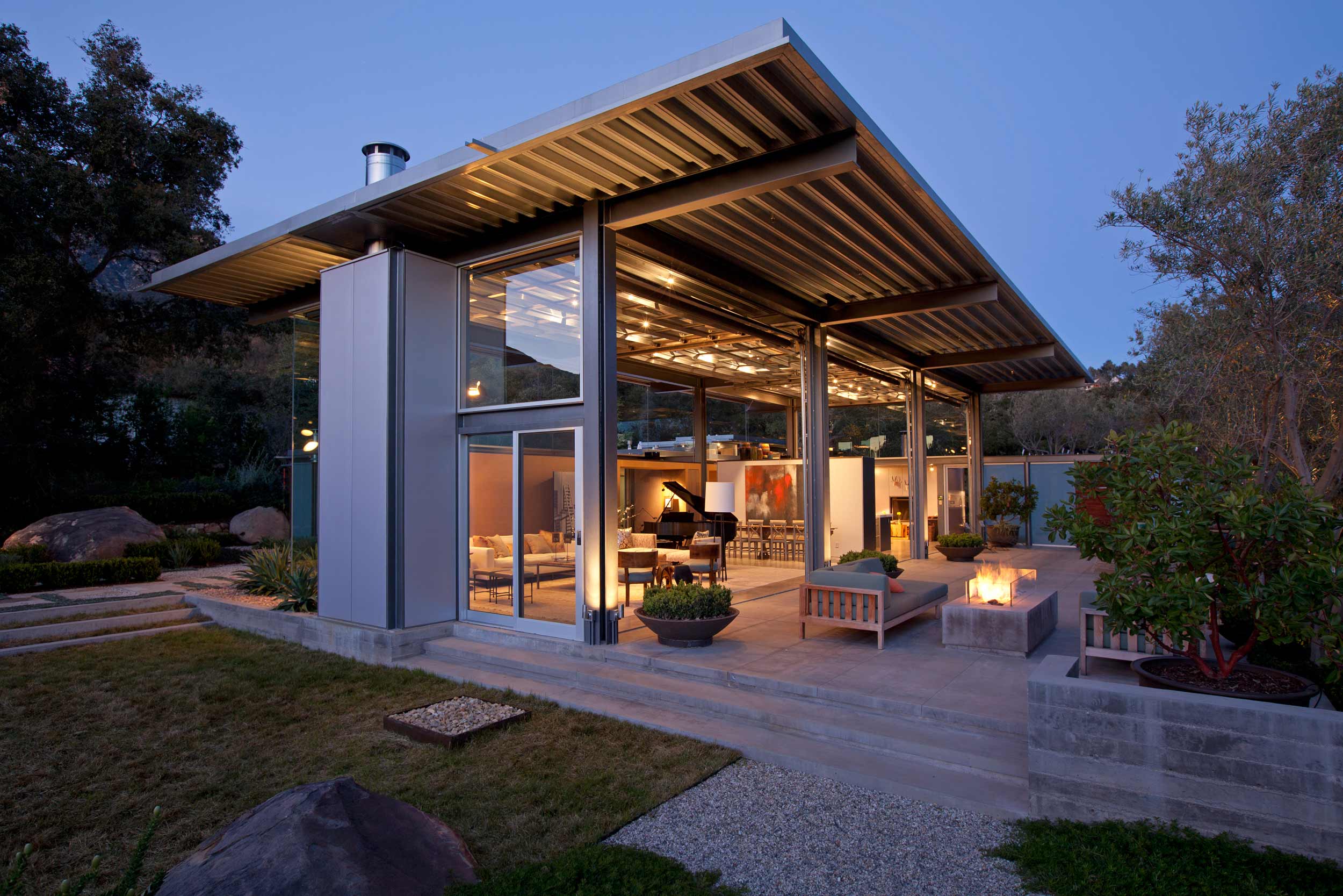 home and garden at dusk with architectural overhang roof