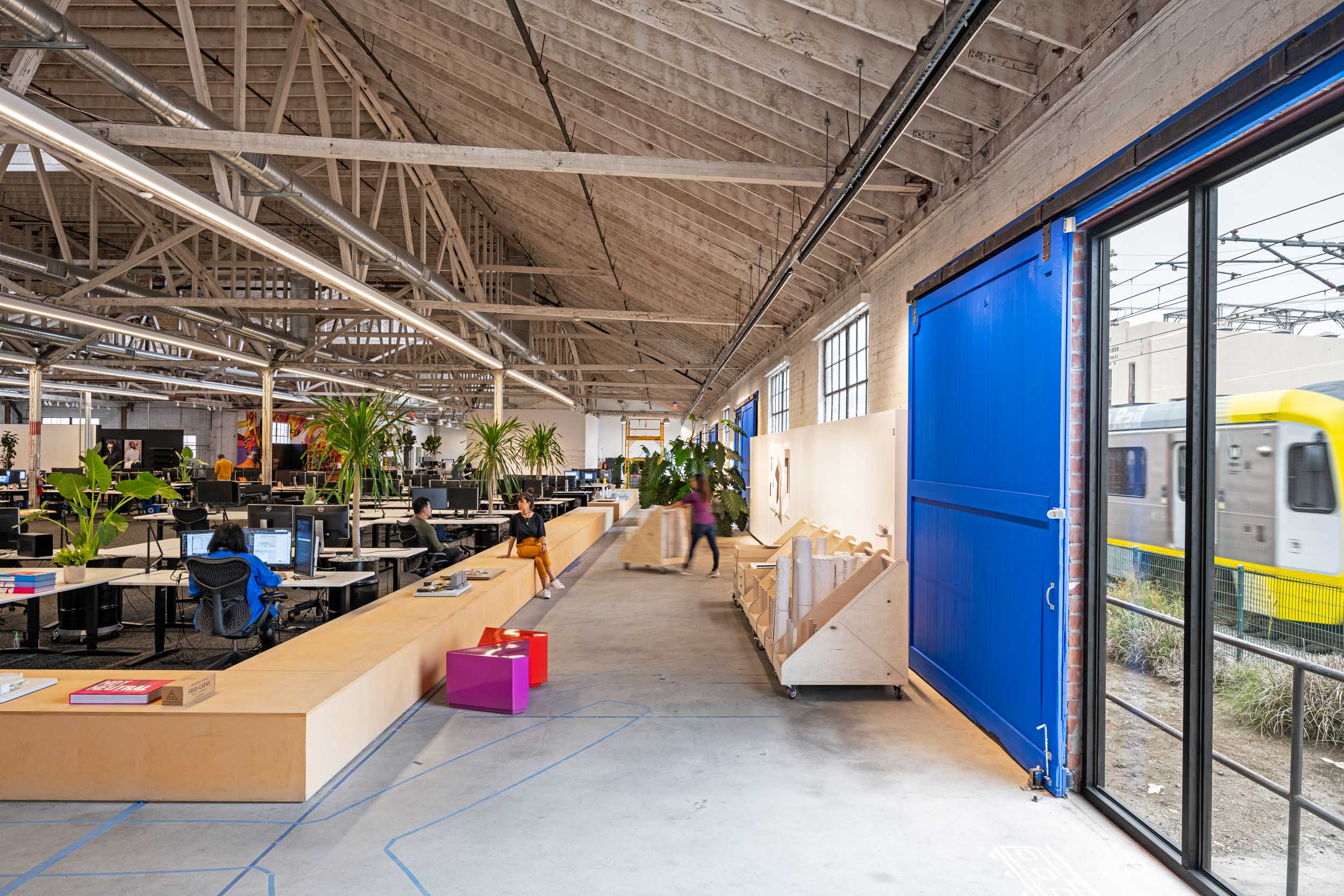 interior view of RIOS office with large blue barn doors open, showing the next door train tracks