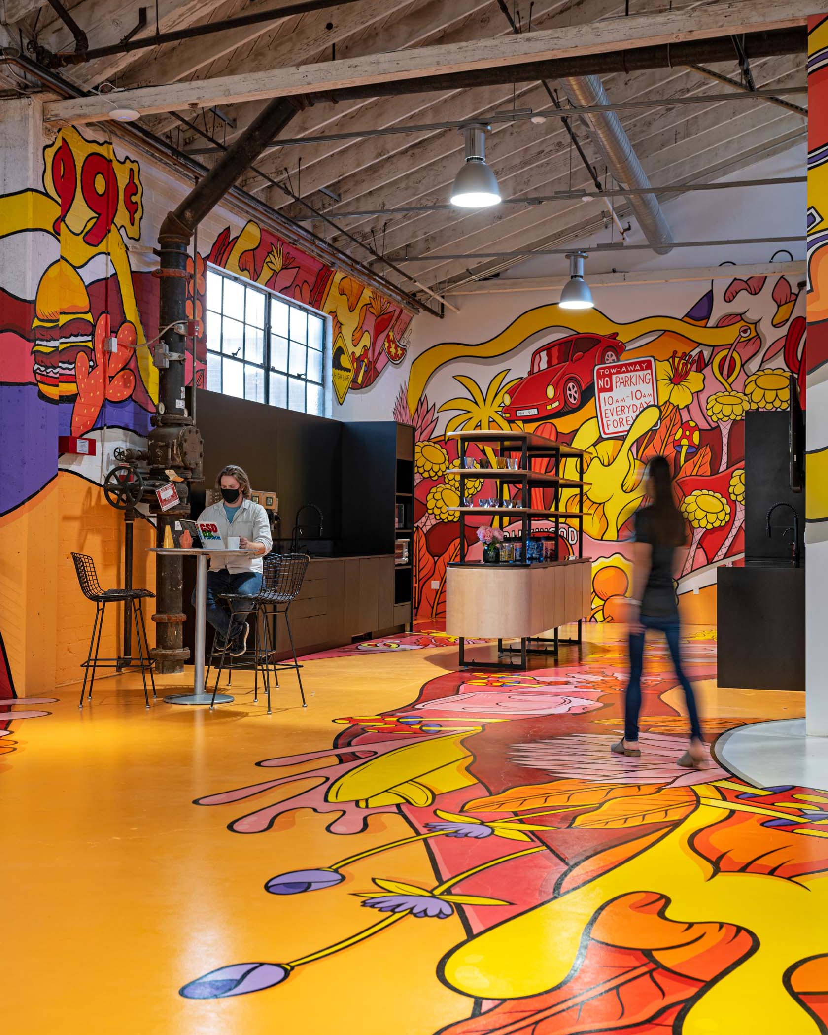 woman walking in RIOS kitchen with colorful wall and floor murals