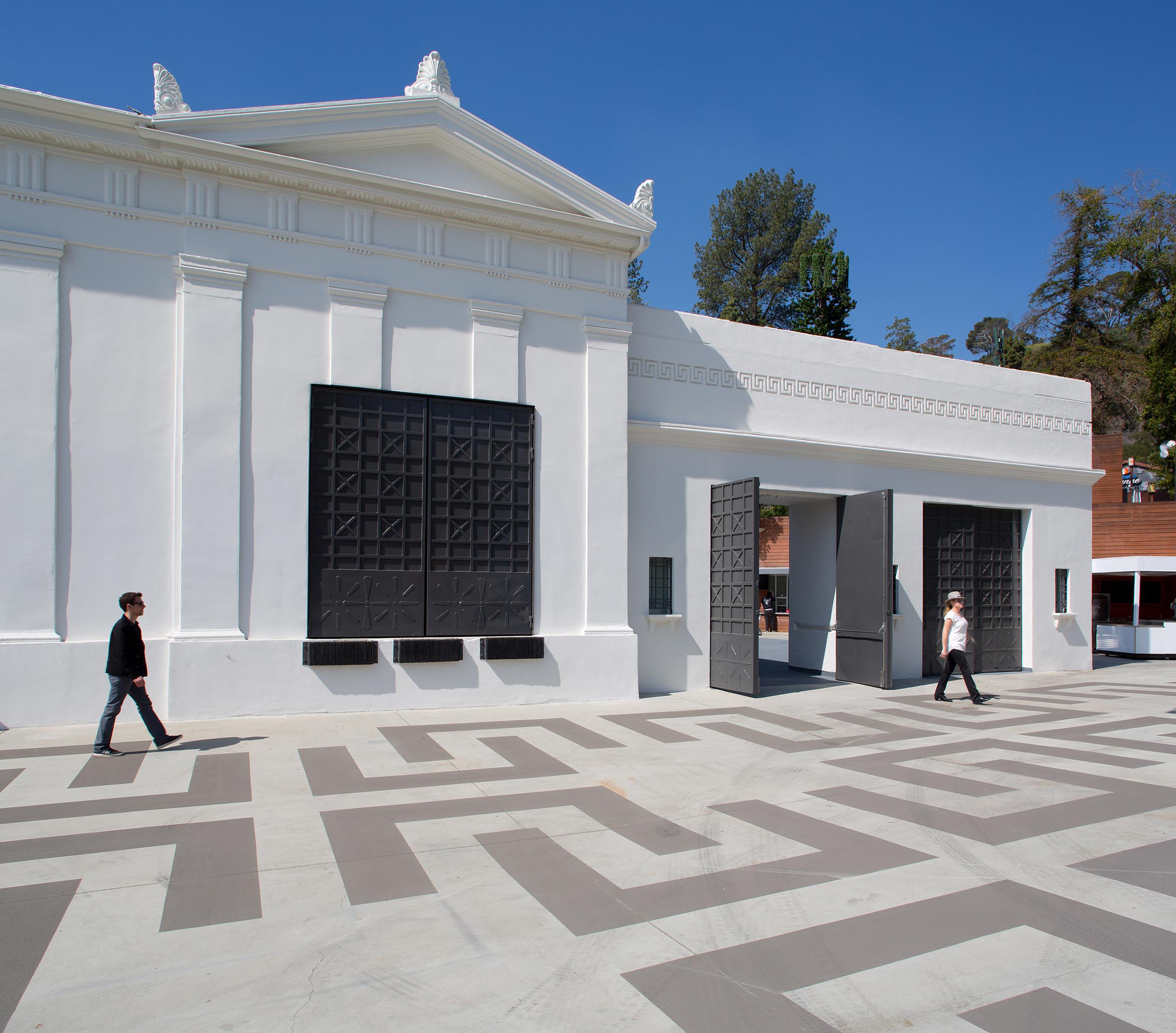 exterior view of white greek-inspired theater with large black door and windows