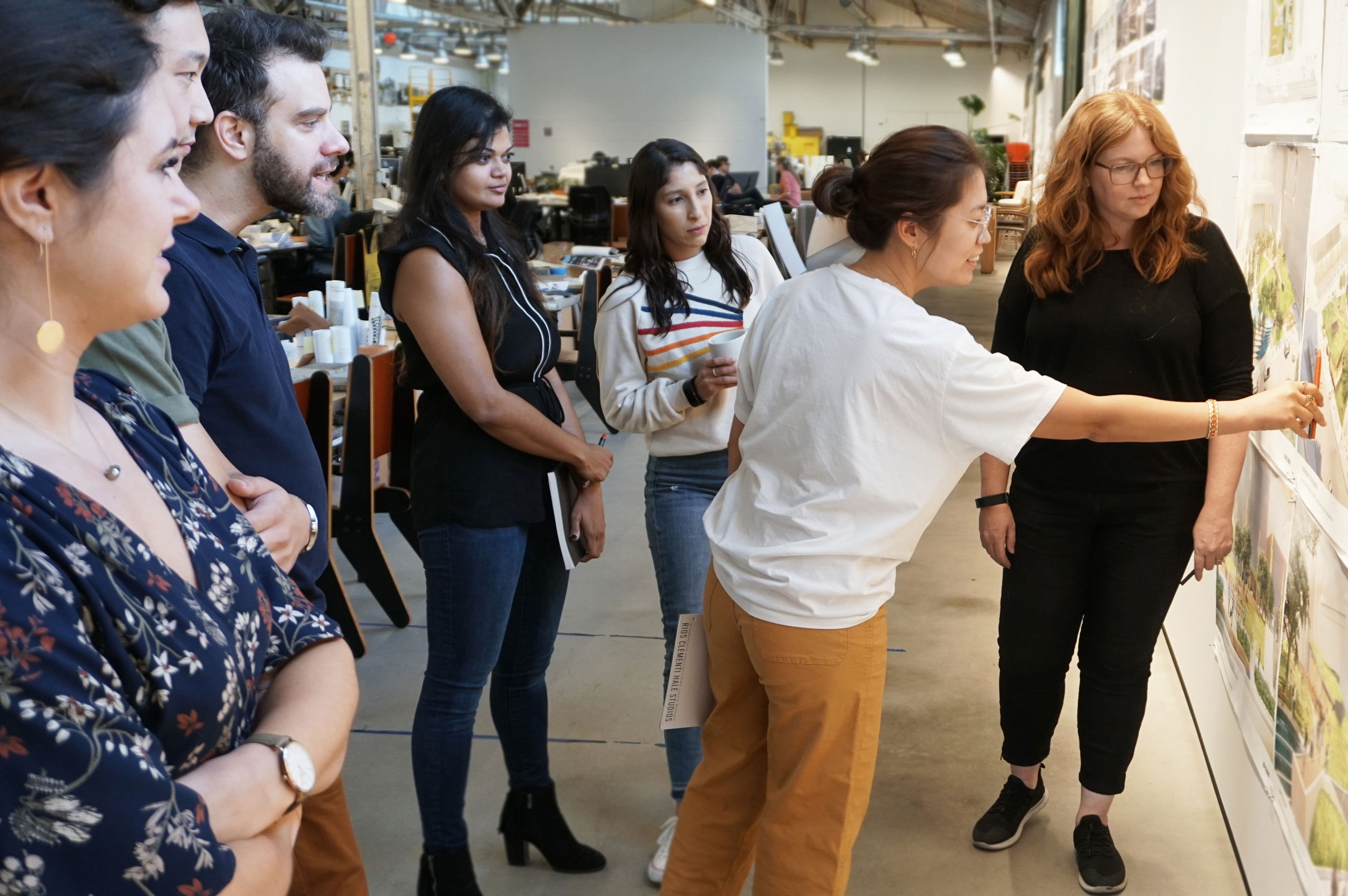 A group of people pointing at something on the wall