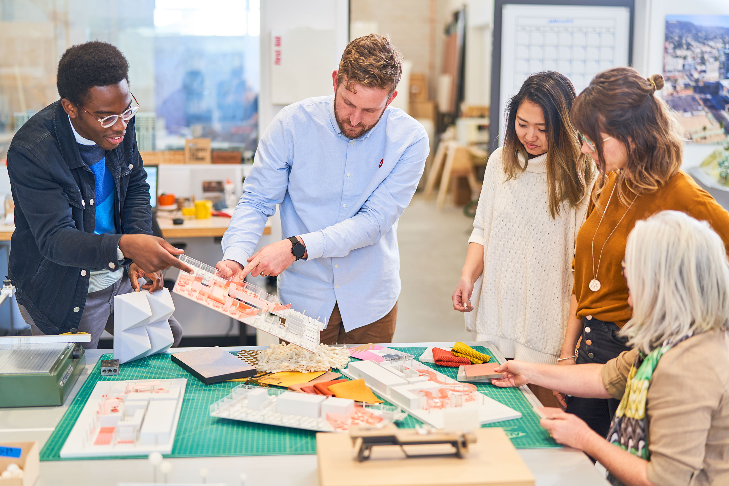 People working around a table with building models and materials