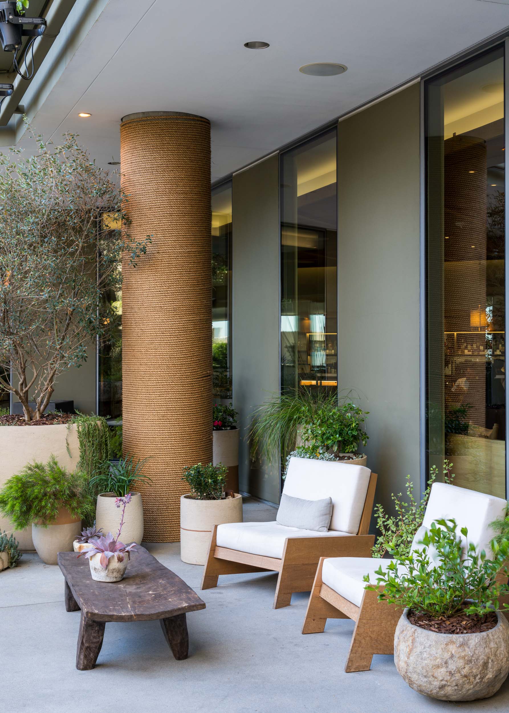 outdoor lounge with modern white chairs and jute wrapped pole