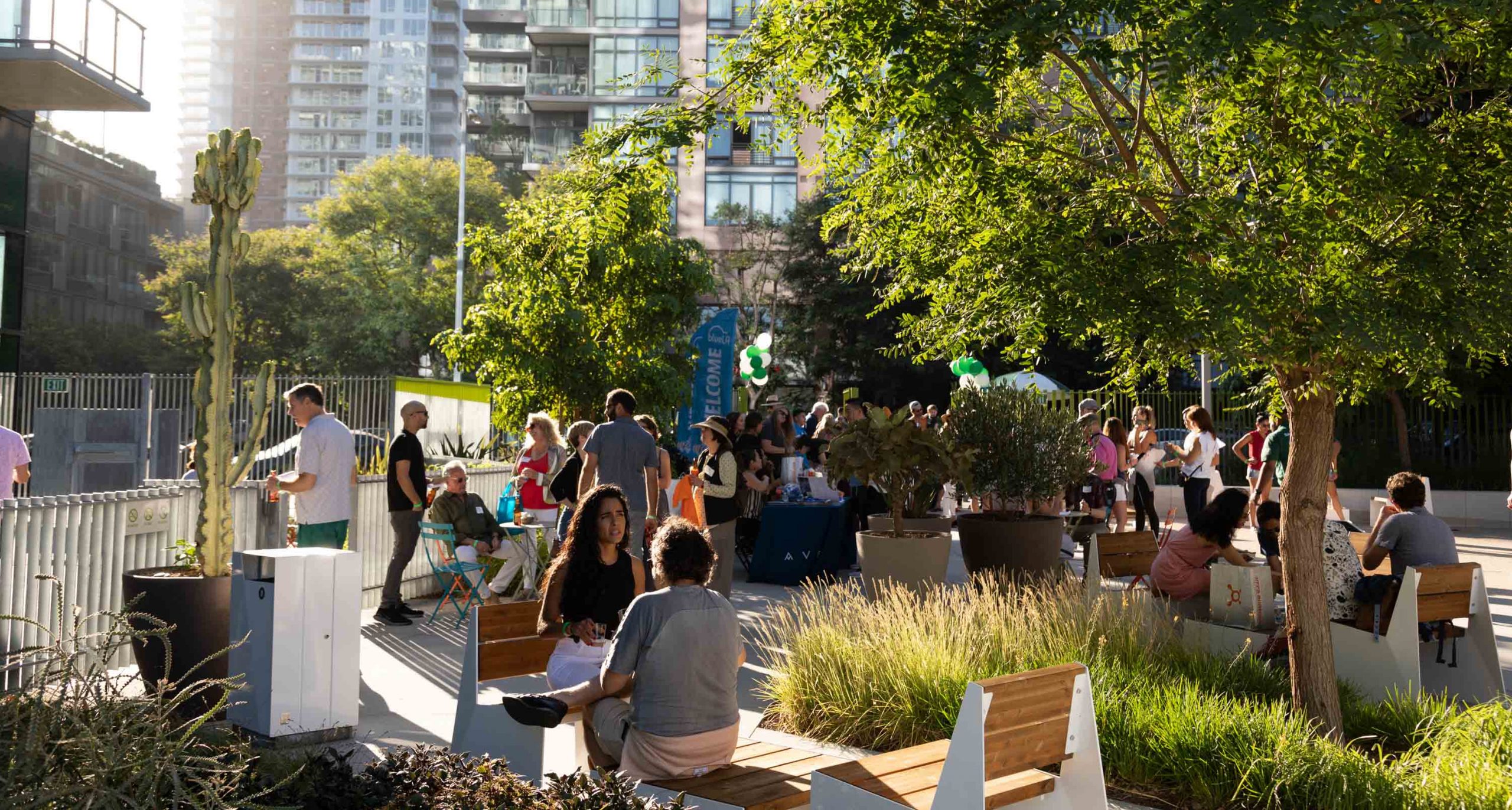 people seated in an outdoor patio underneath trees