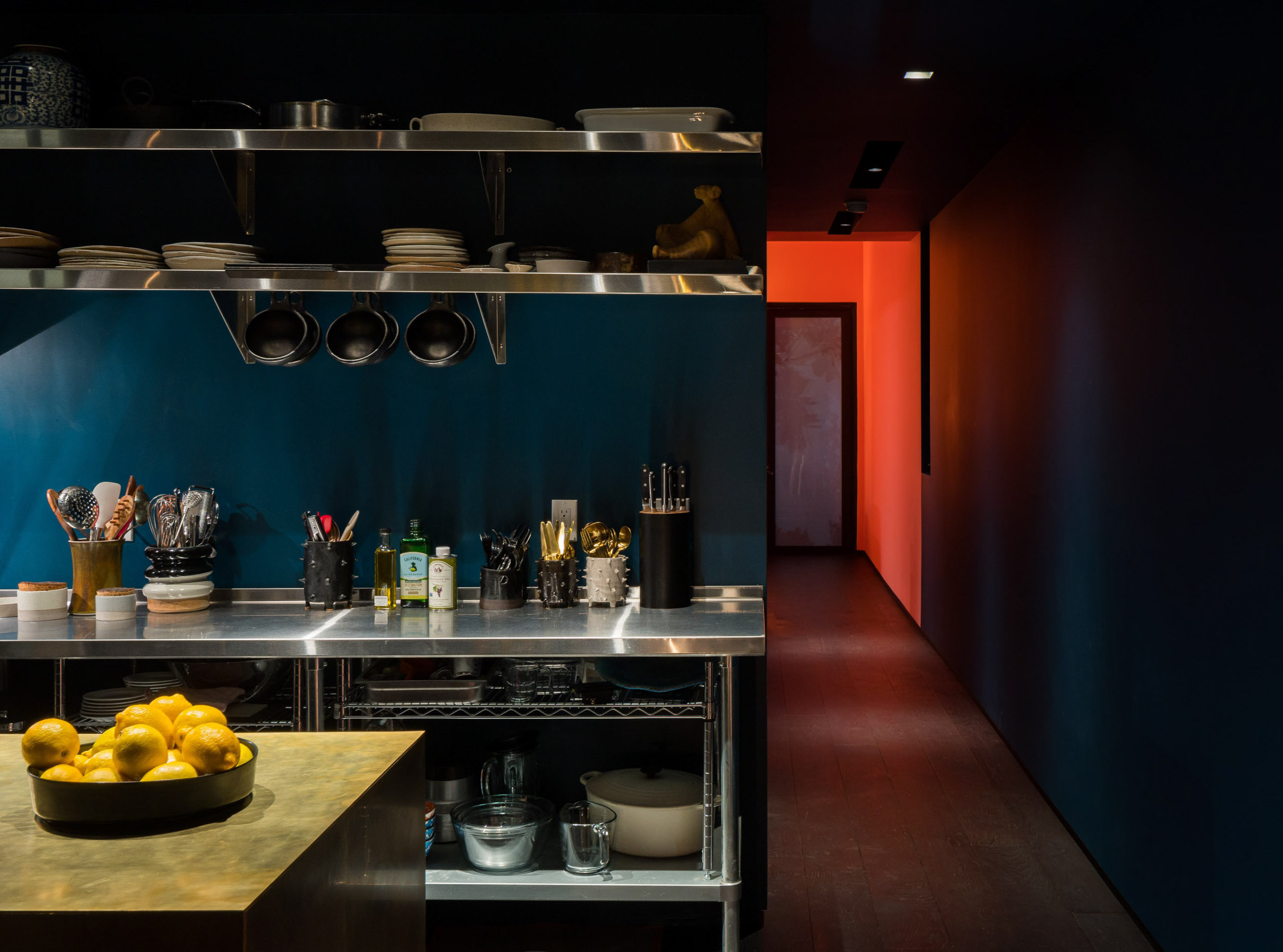 modern kitchen with blue wall and red hallway