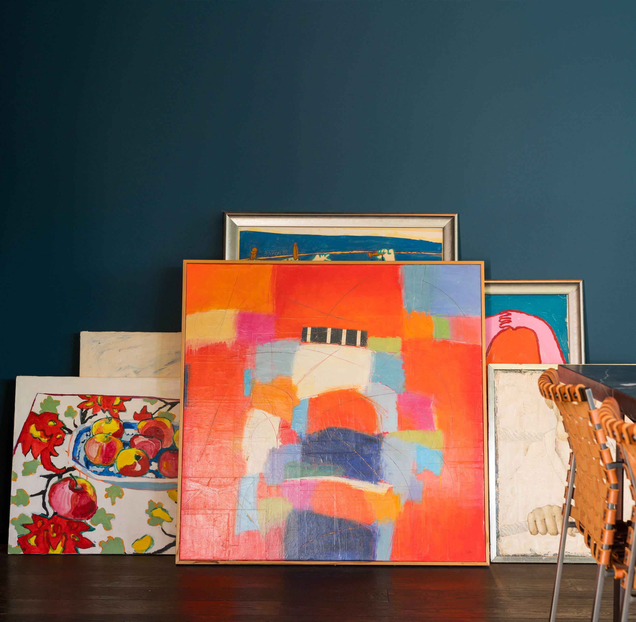 brightly colored abstract paintings leaning against wall