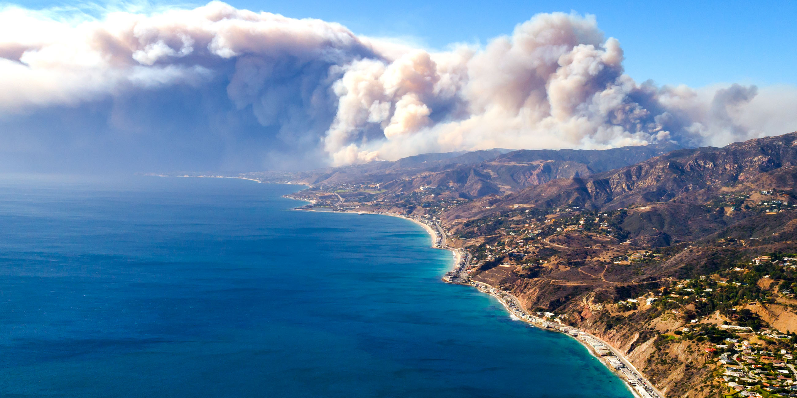 beachside mountains with the Woolsey fire burning in the back mountains