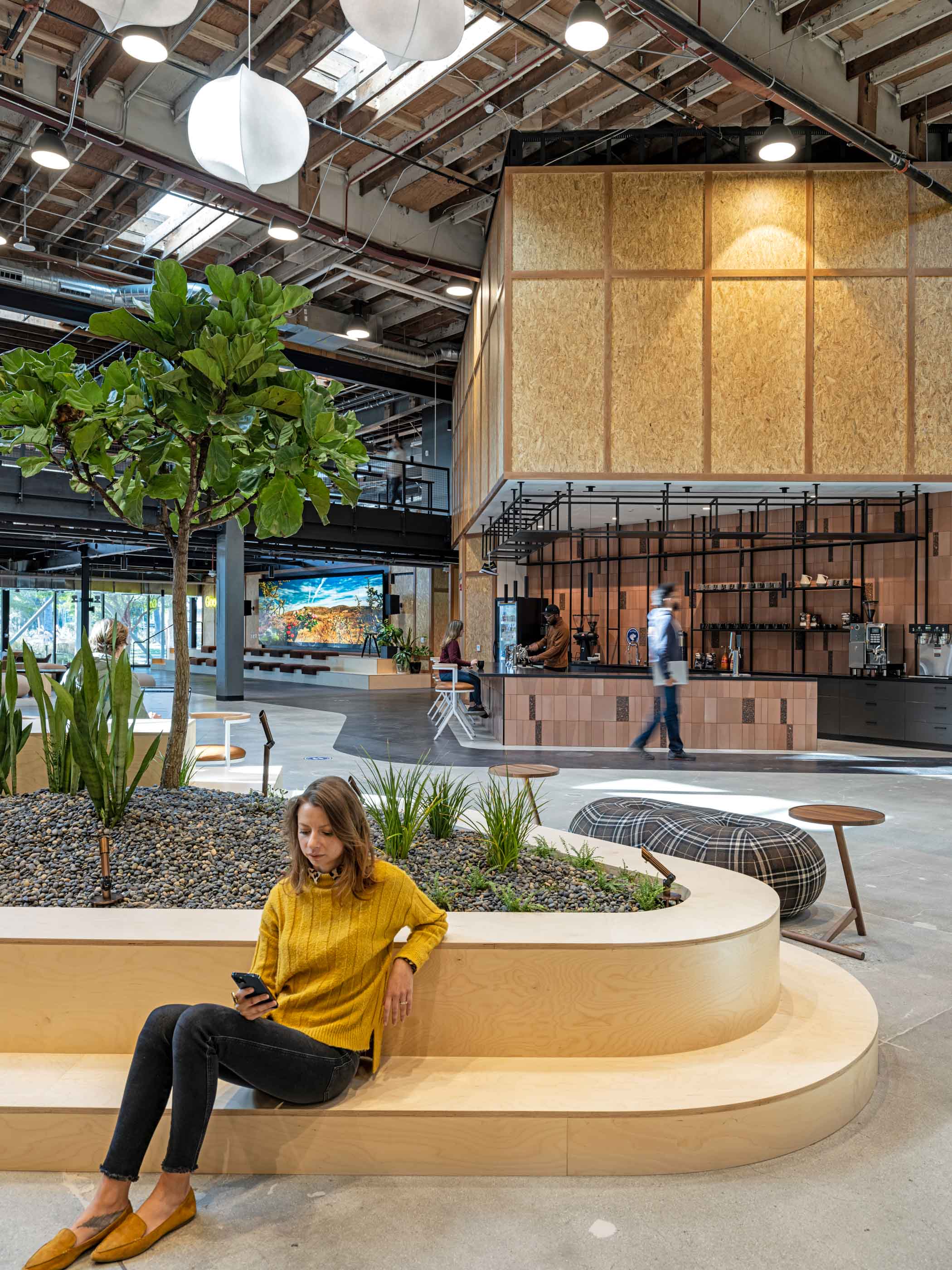 Woman seated at a planter bench with a GoodRx wellness space in the background