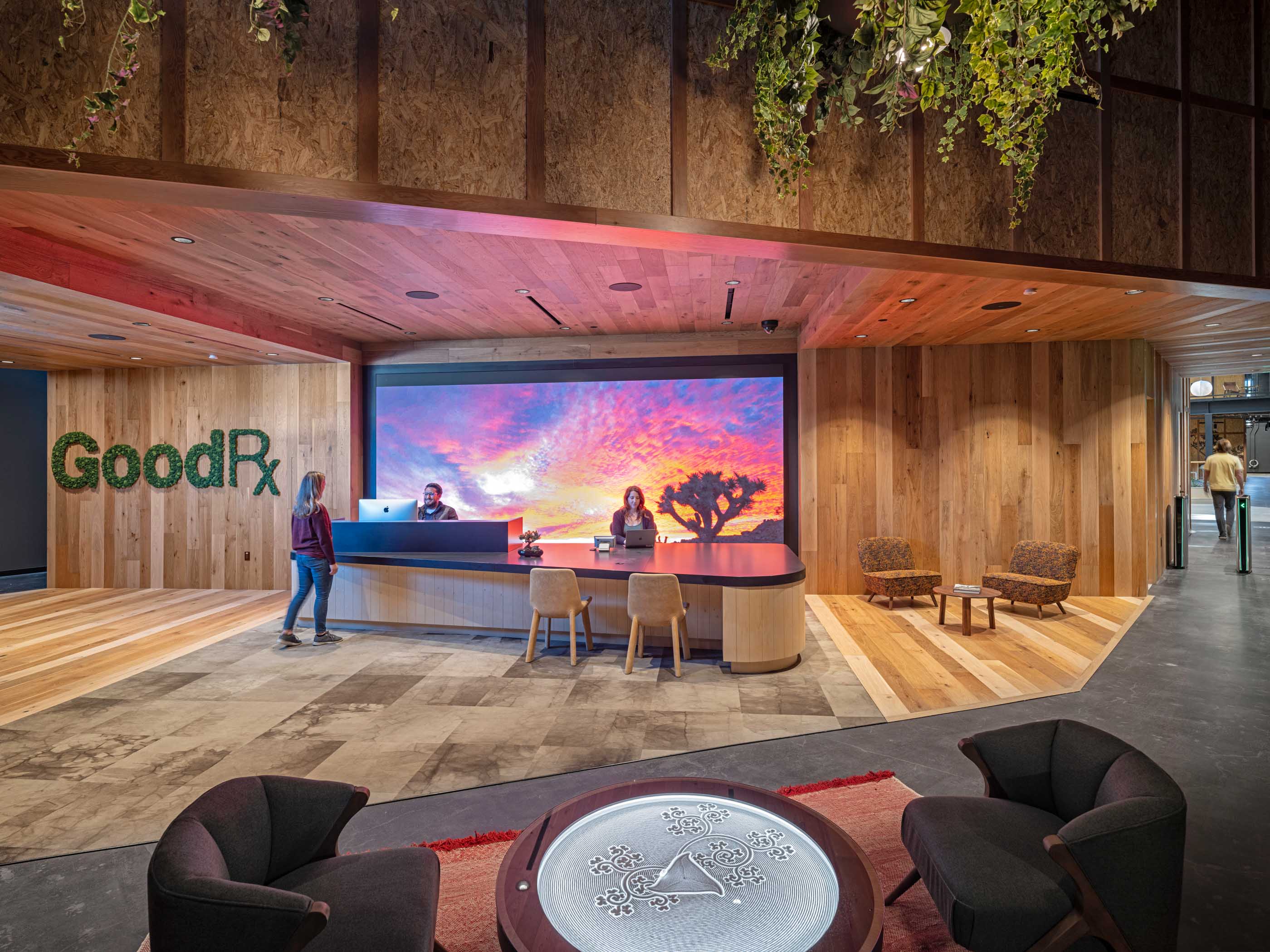 GoodRx lobby front desk with screen showing a sunset on the wall and plants hanging from the ceiling