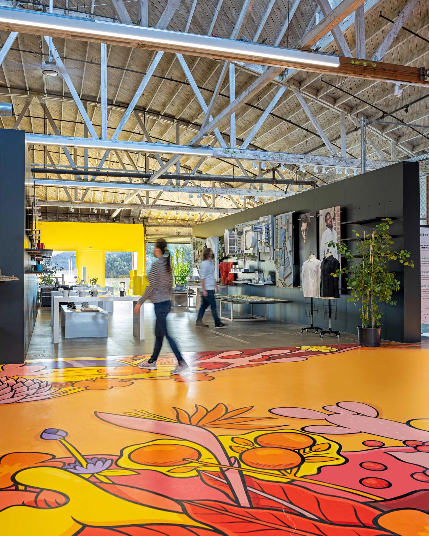 Interior shot of RIOS office with colorful floor mural and industrial ceilings