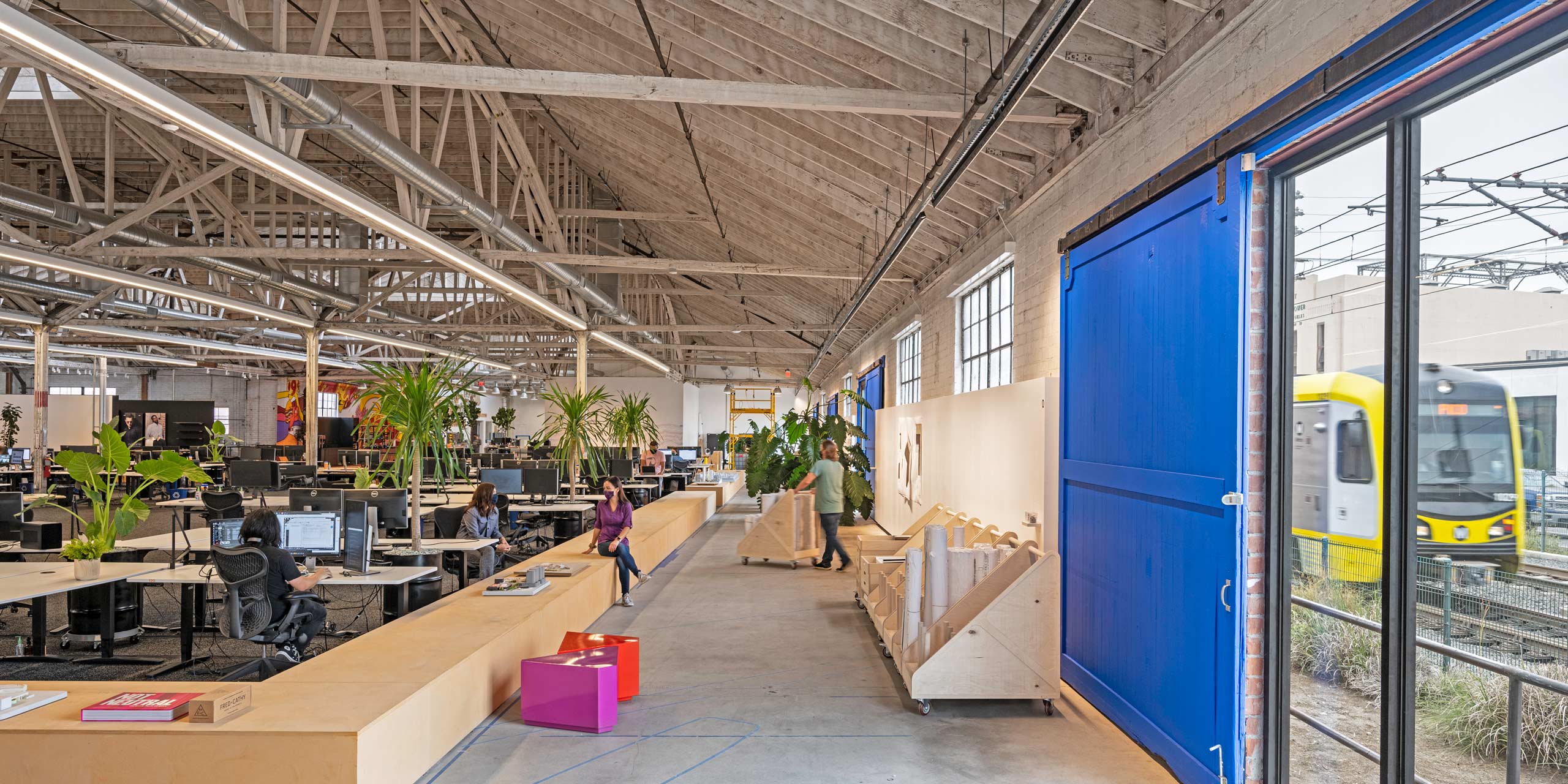 interior view of RIOS office with large blue barn doors open, showing the adjacent train tracks