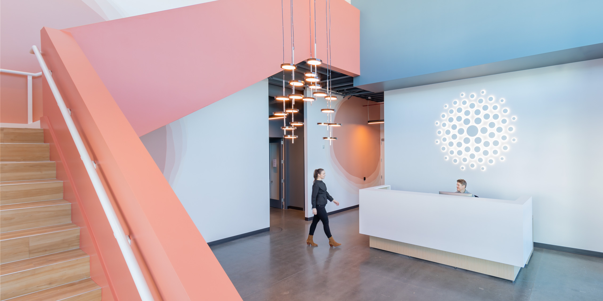 Entry to life sciences offices with reception and light pink stairway