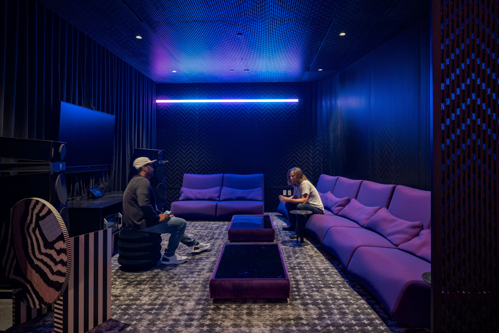 Looking into Spotify's listening lounge with purple couches and blue neon lights