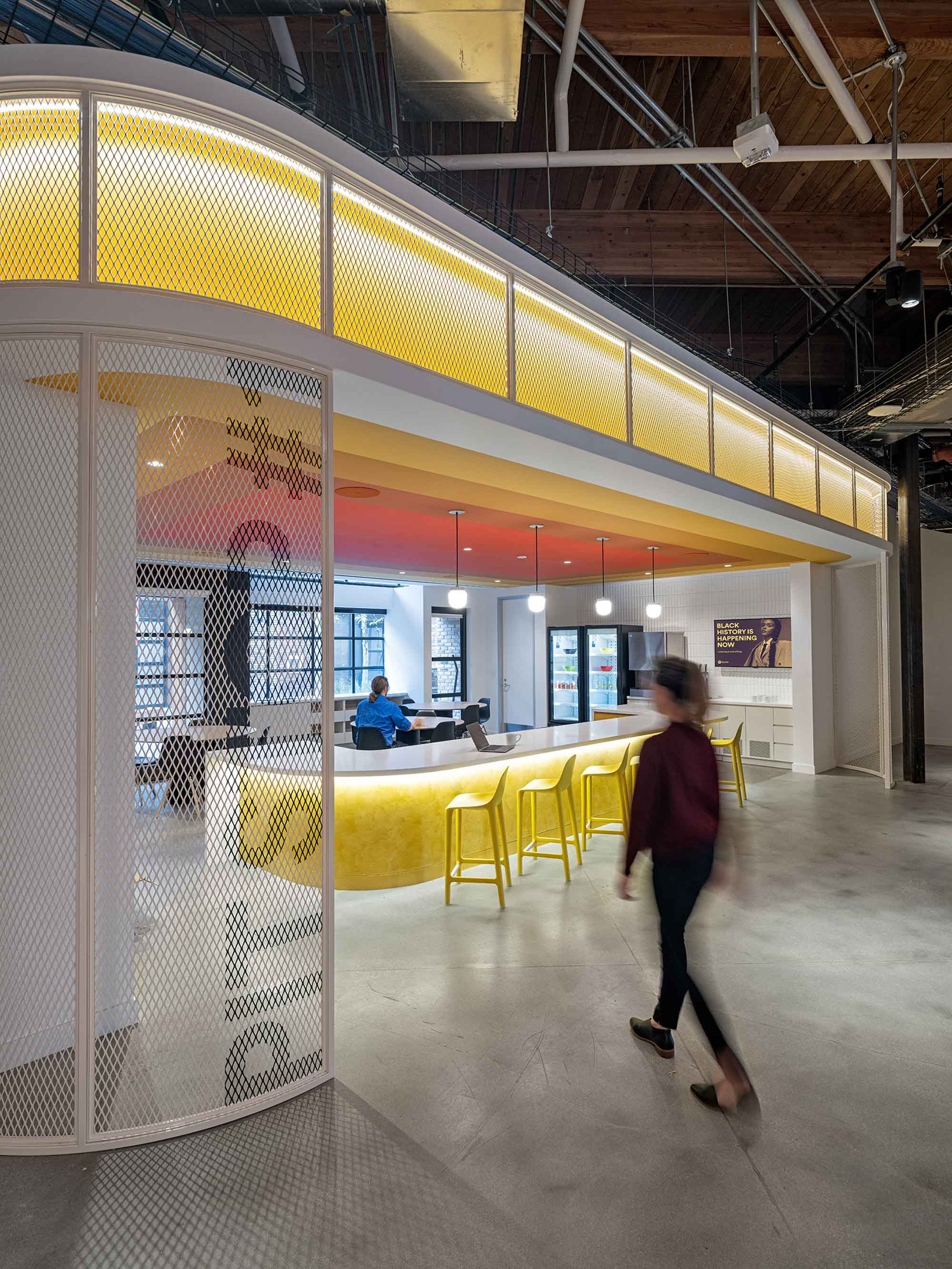 Woman walking into the yellow and bright cafe lunch area