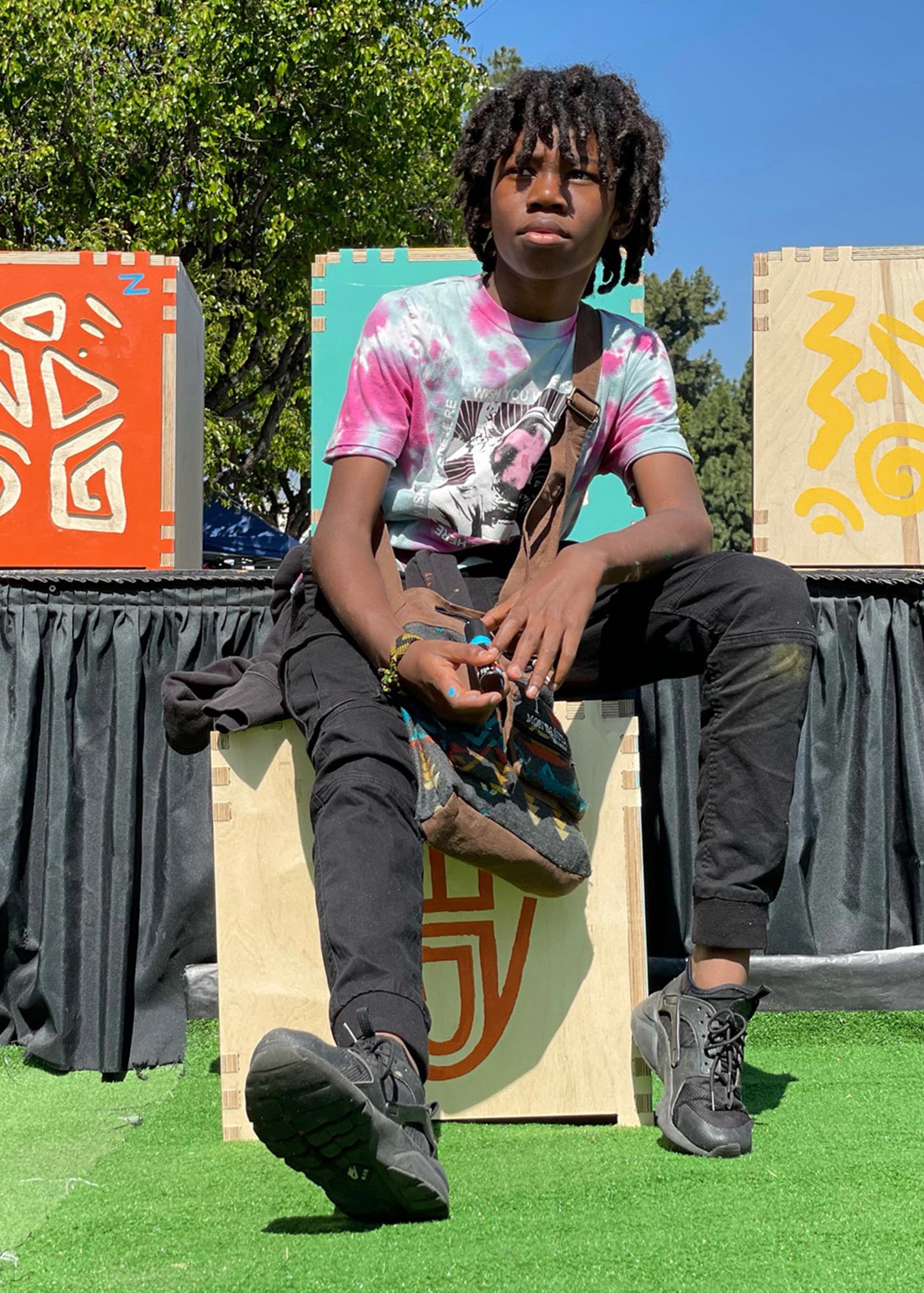 Boy sitting on a cube with three cubes behind him