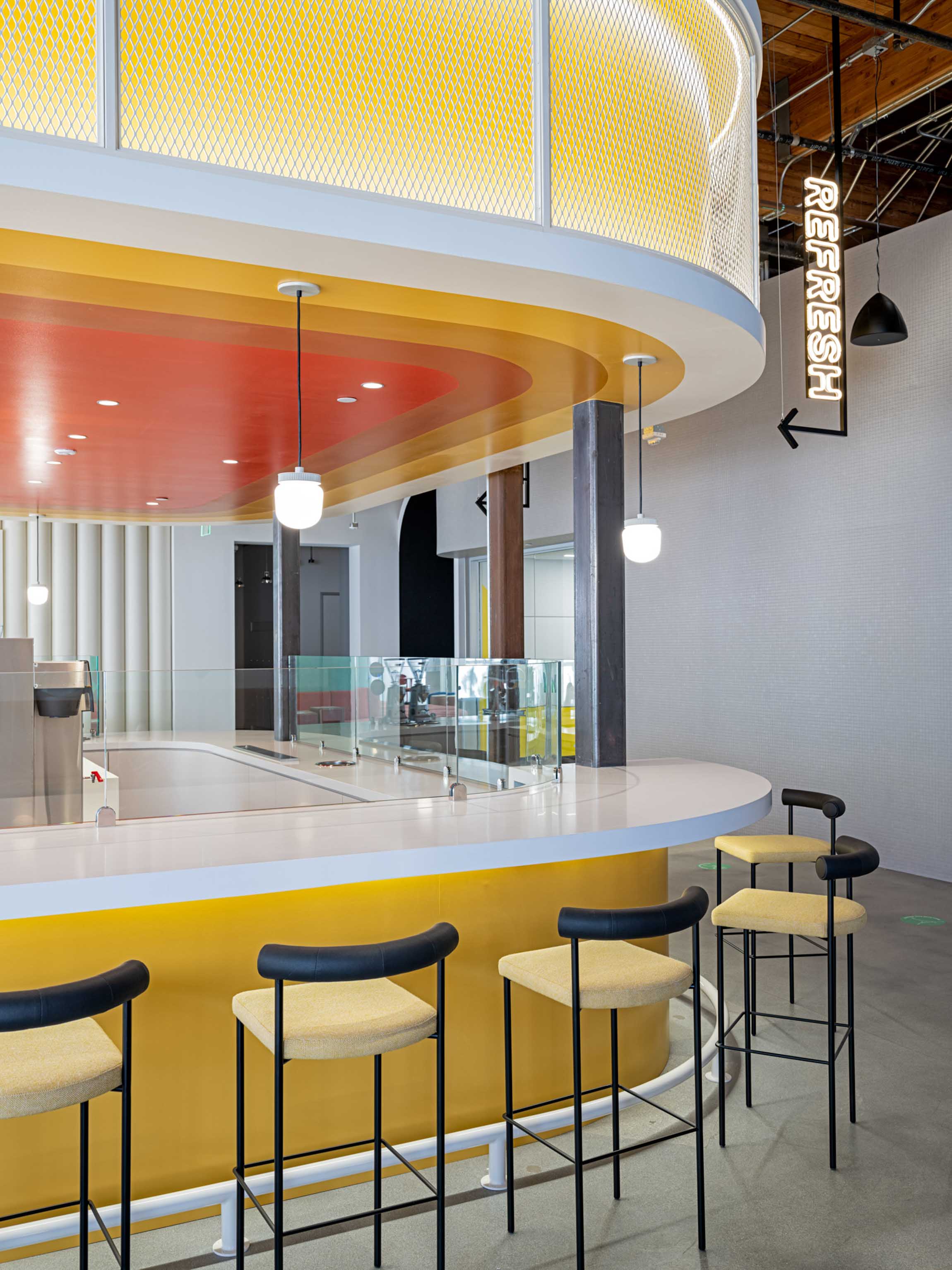 Clean refreshment bar with yellow to red gradient ceiling and yellow bar stools