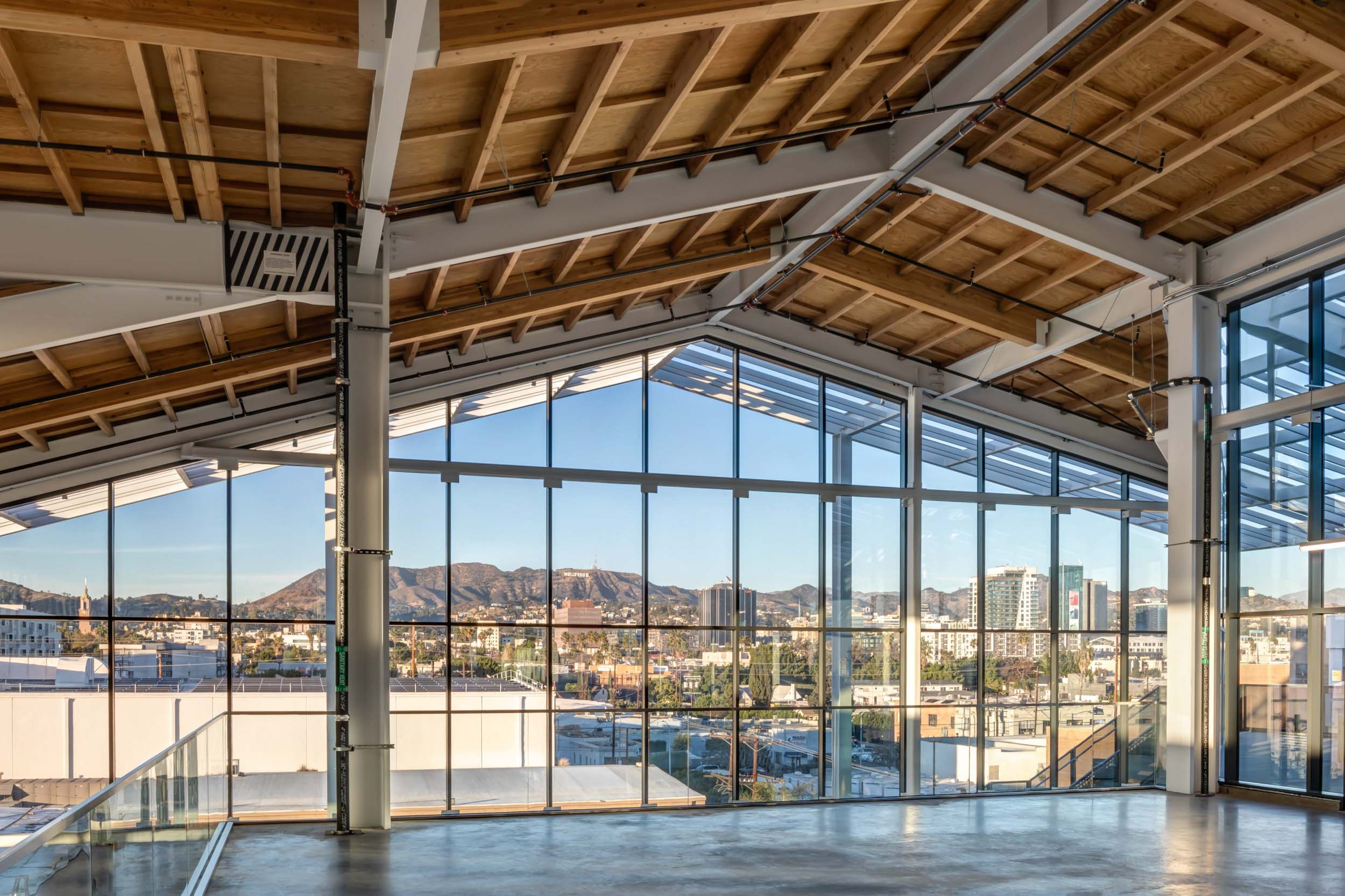Inside the building at Harlow looking out the floor-to-ceiling windows at the Hollywood Hills