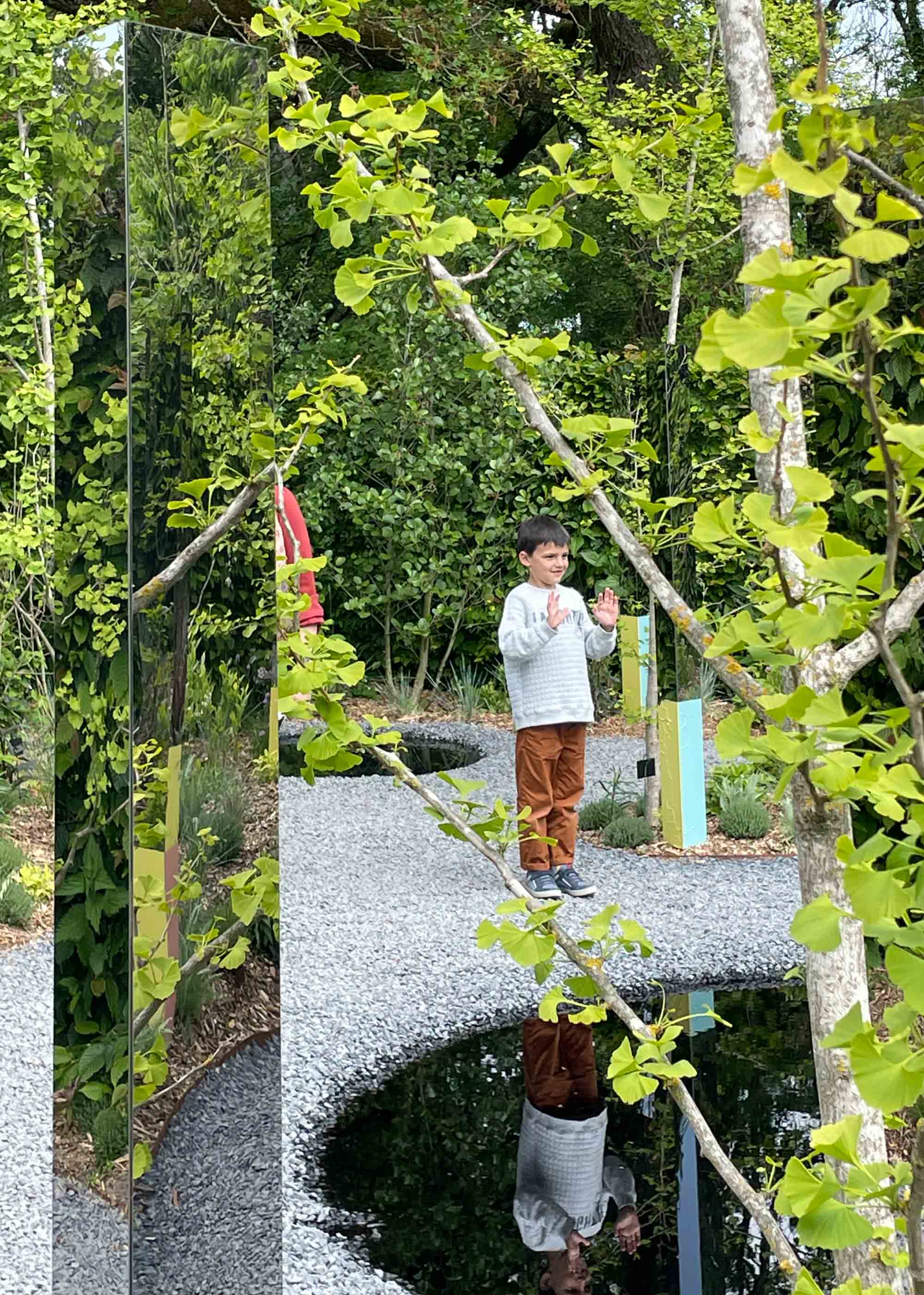 Child looking in a reflecting pond at the Garden of Reciprocity