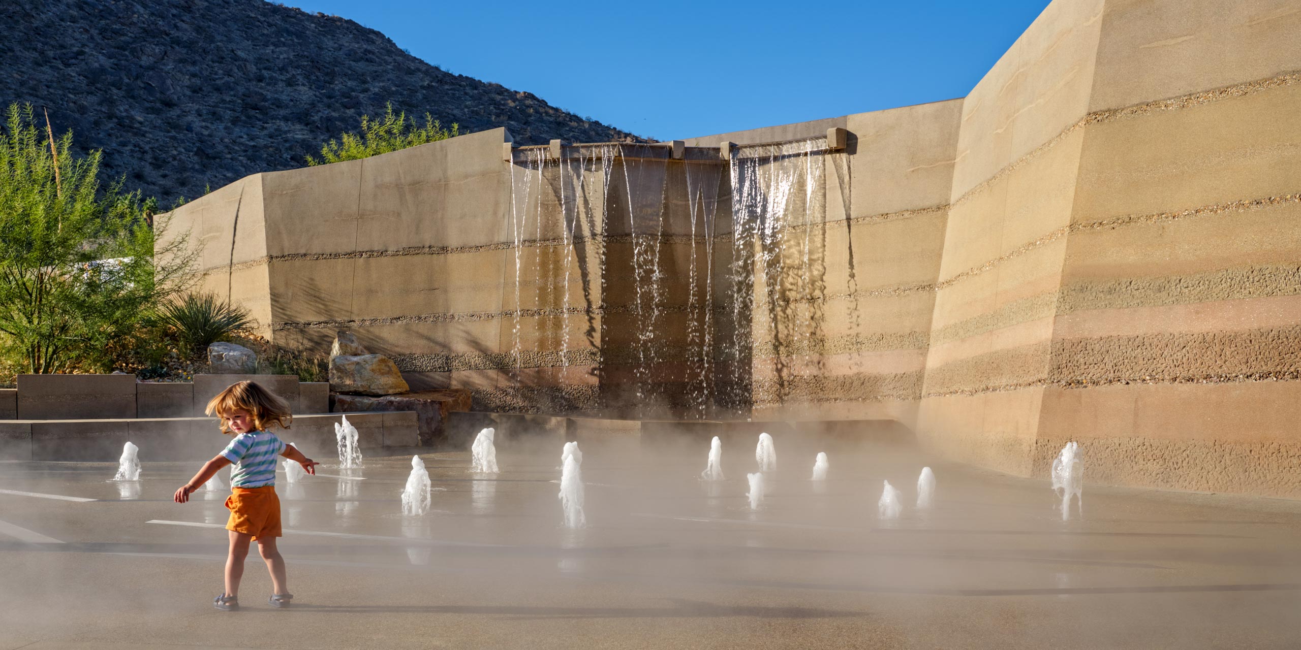 kid playing in water feature