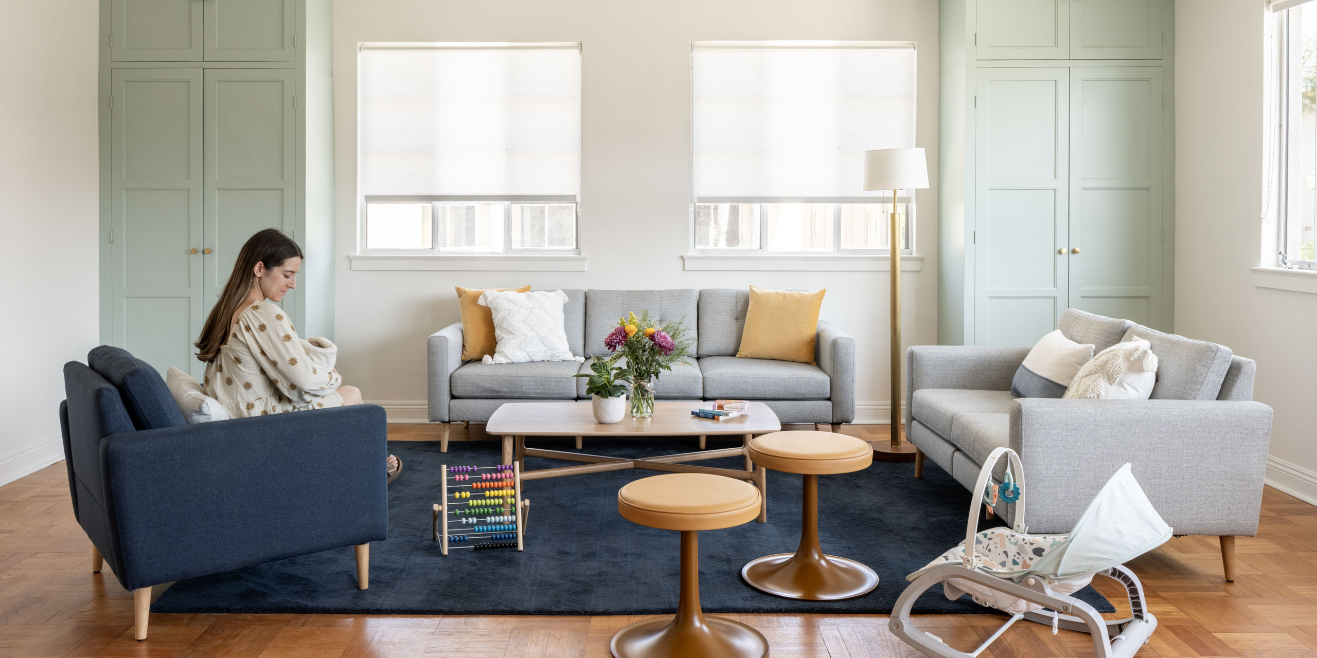 Mother holding baby in communal space with couches and chairs