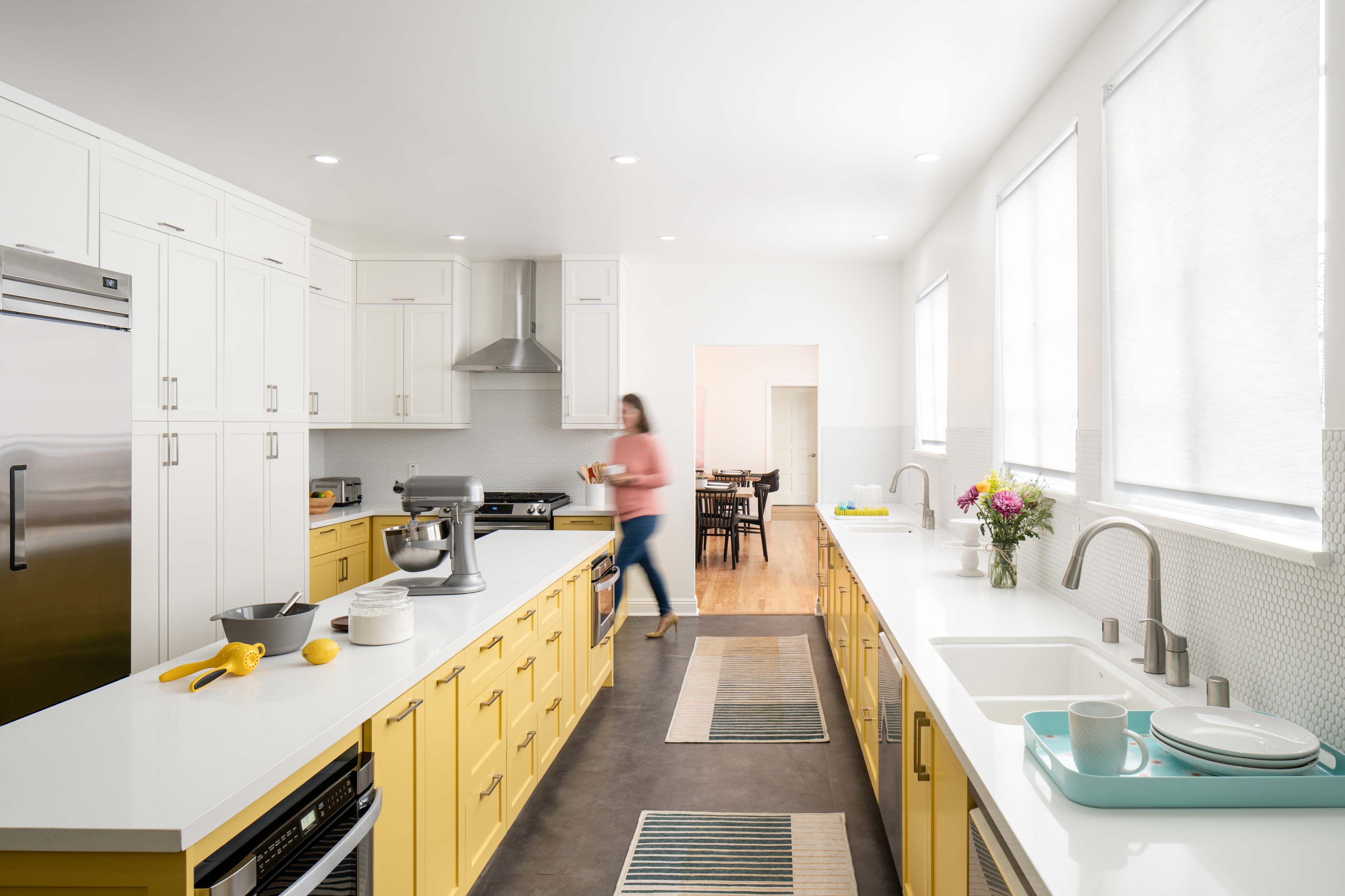 Spacious kitchen with yellow cabinetry and clean white counters