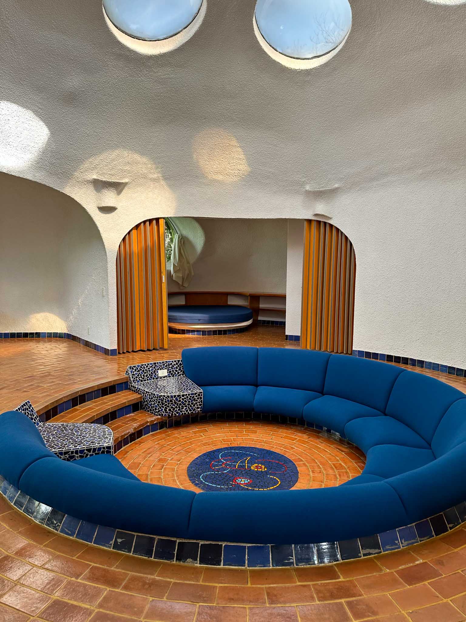 Interior view of a residence at Conjunto Satelite, featuring a rotund sofa surrounding a communal gathering area