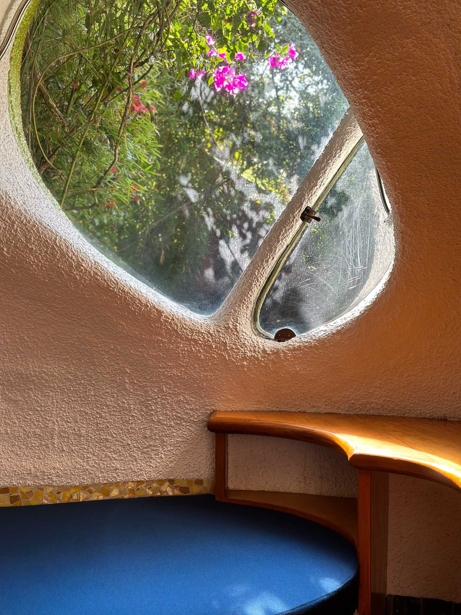 Interior view of a residence at Conjunto Satelite, featuring an oblong window and curved bench