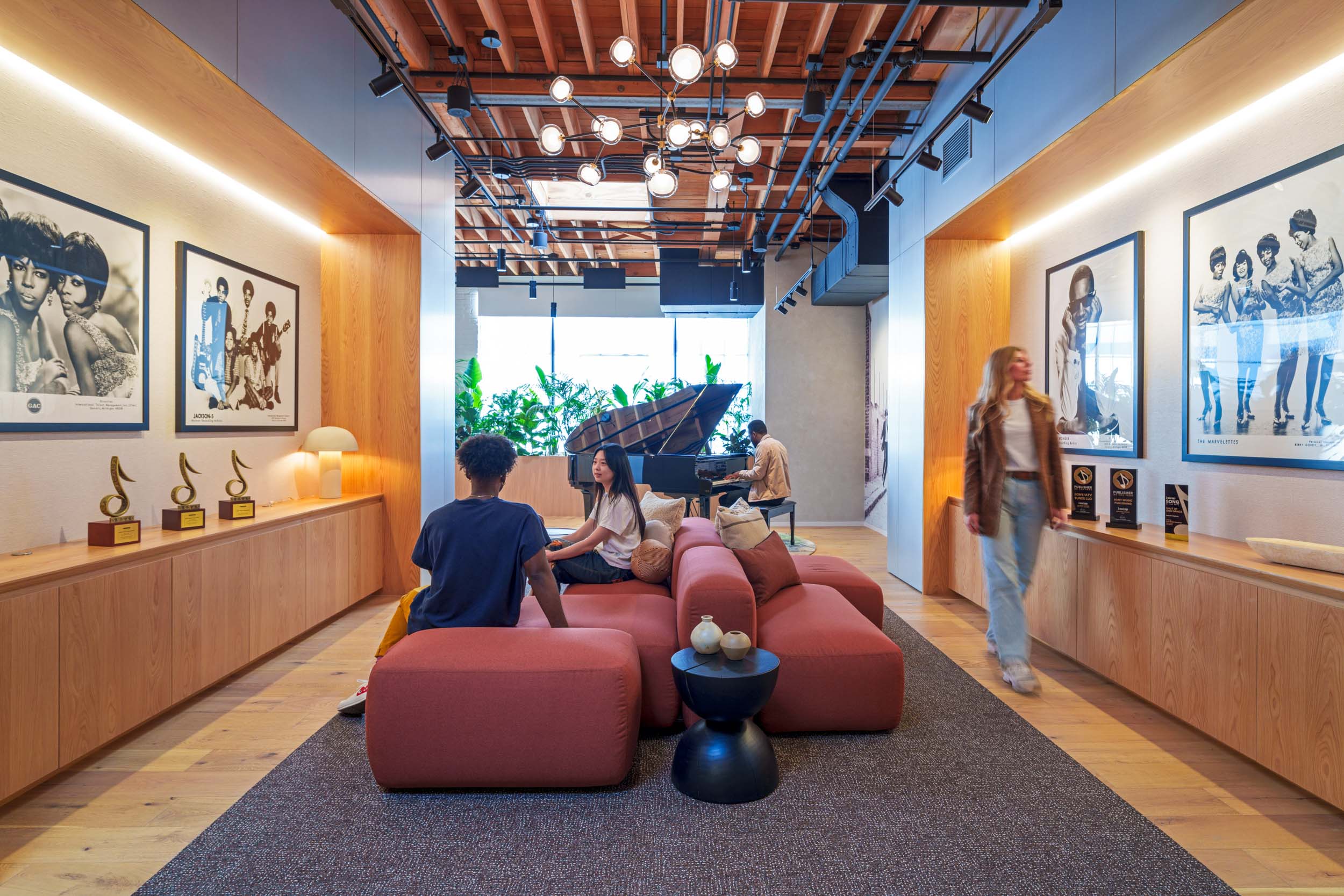 Reception at Sony Music Publishing, featuring artist photography, Grammy awards, and a grand piano — the label's catalog embedded in the space / content creation workplace
